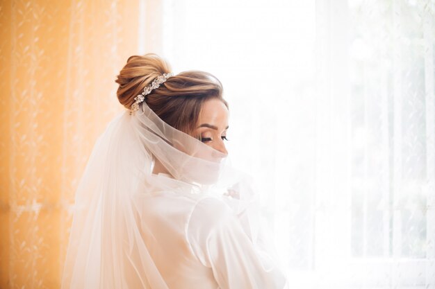 Novia con vestido blanco posando mientras se prepara para la ceremonia de la boda