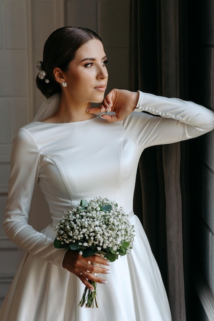 Foto una novia en un vestido blanco con un ramo de flores