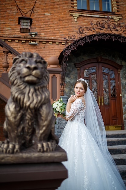 Novia con un vestido blanco con un ramo en las manos y una corona en la cabeza.