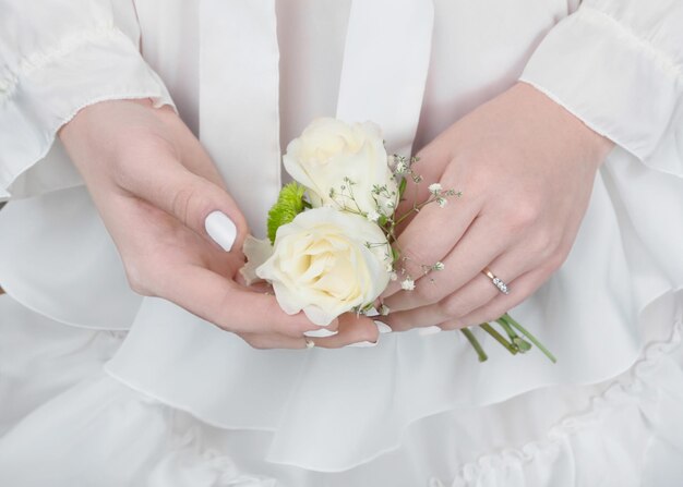 Novia con un vestido blanco con un ramo de rosas en las manos