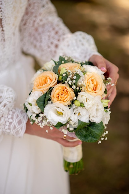 La novia con un vestido blanco sostiene un ramo de flores en sus manos idea para agencias de eventos de bodas