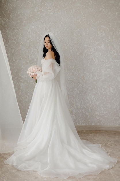 una novia en un vestido blanco con un velo en la cabeza