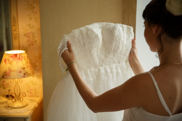 Novia con vestido de bodas en una habitación cálida