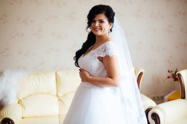 Novia con vestido de moda posando en la mañana de la boda