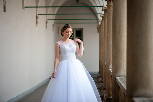 Una novia con un vestido de novia blanco camina por un edificio