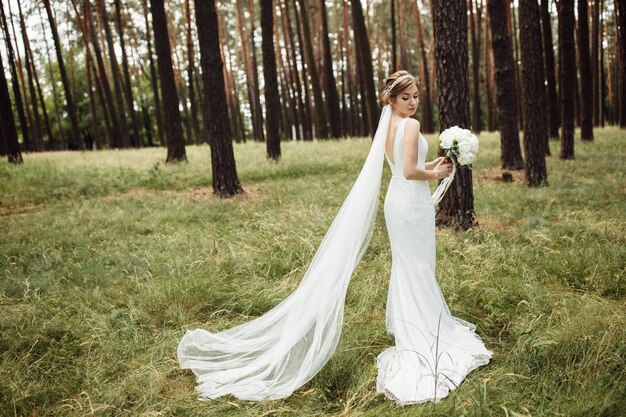 Novia con un vestido de novia blanco con un ramo de flores