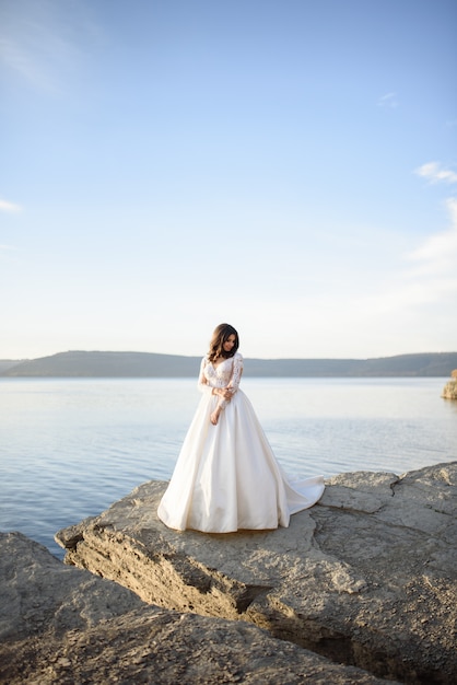 Novia en vestido de novia cerca de un lago