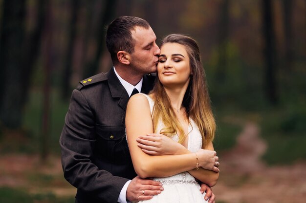 La novia con vestido de novia cruzó los brazos y cerró los ojos y