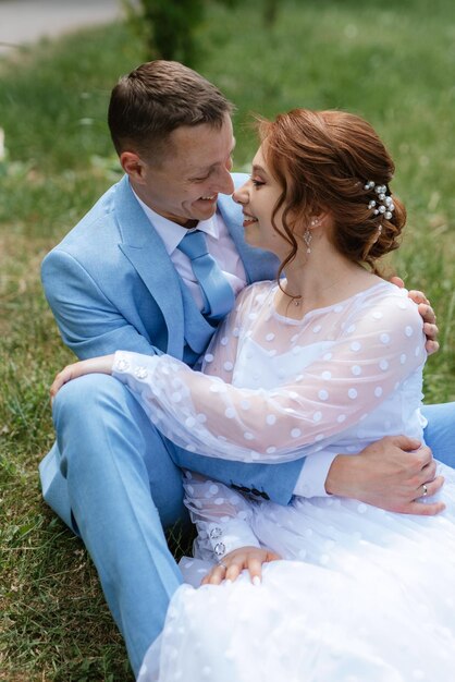 Novia con un vestido de novia ligero para el novio con un traje azul.