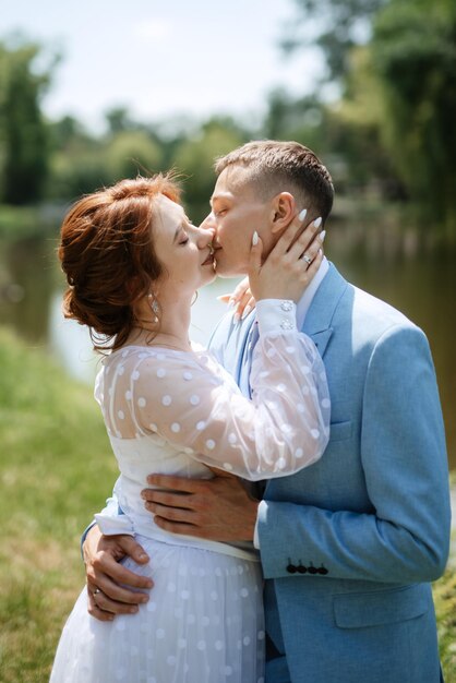 Novia con un vestido de novia ligero para el novio con un traje azul.