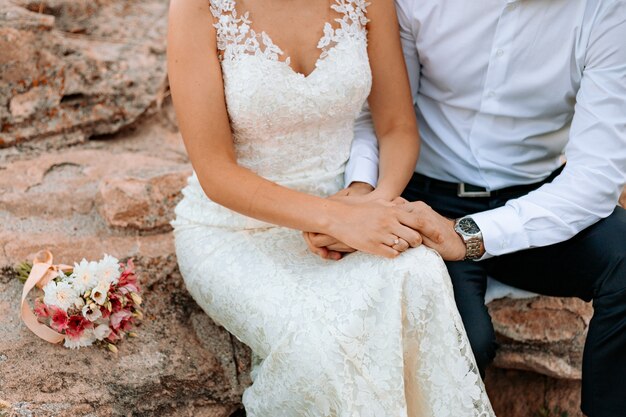 Foto la novia en el vestido de novia y el novio tomados de la mano