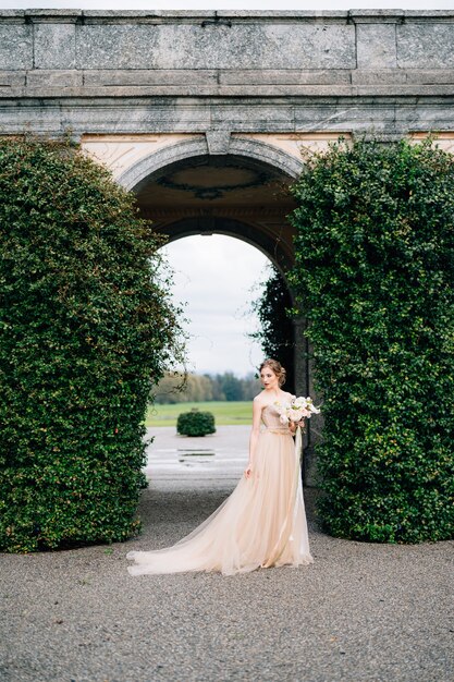 Novia con un vestido rosa con un ramo de flores