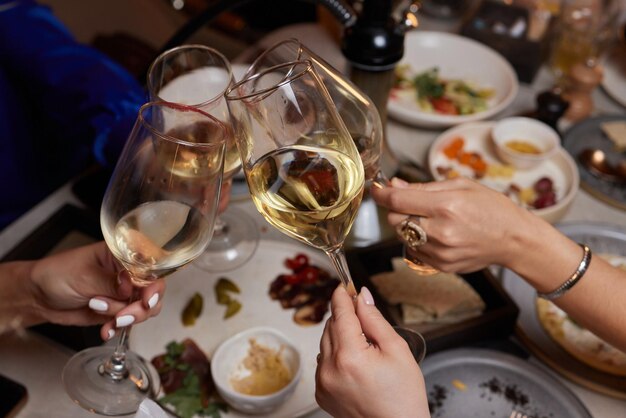 Novias bebiendo vino y animando mientras están sentadas en el bar Enfoque selectivo en las gafas