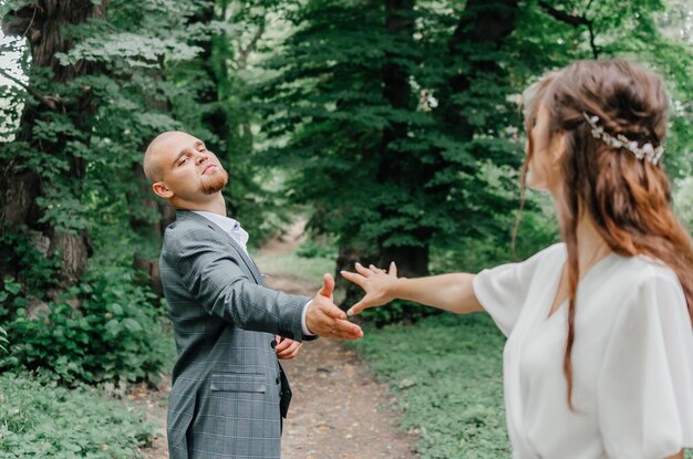 las novias se toman de la mano y caminan en la naturaleza