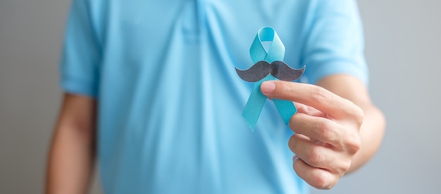 Noviembre, mes de concientización sobre el cáncer de próstata, hombre que sostiene la cinta azul con bigote para apoyar a las personas que viven y están enfermas. Concepto de salud, hombres internacionales, padre y día mundial del cáncer