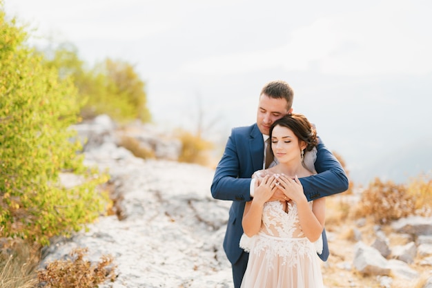 El novio abraza suavemente a la novia por los hombros.