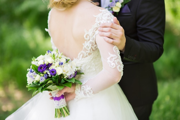 El novio abraza suavemente a su novia en el jardín.