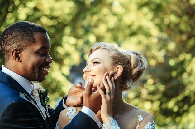 El novio amoroso toca la cara de la novia adorable