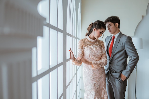 El novio asiático mirando a las hermosas novias que inclinan la cabeza