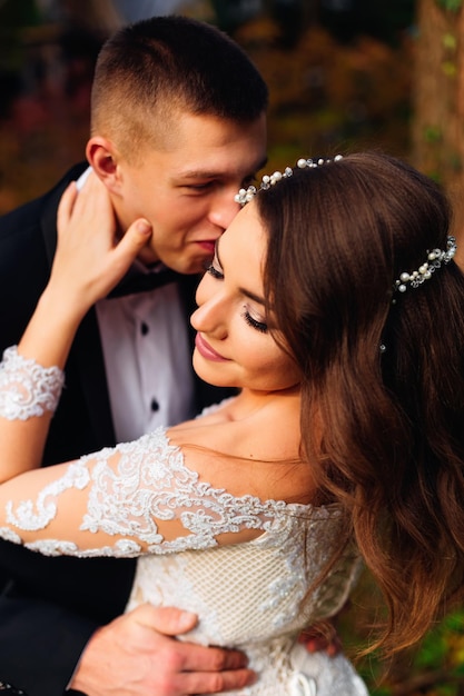 El novio besa a la novia novia con un hermoso maquillaje y un ha
