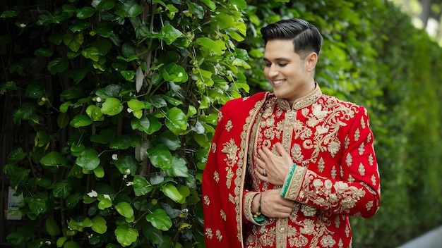 El novio de camisa verde toca su sherwani rojo