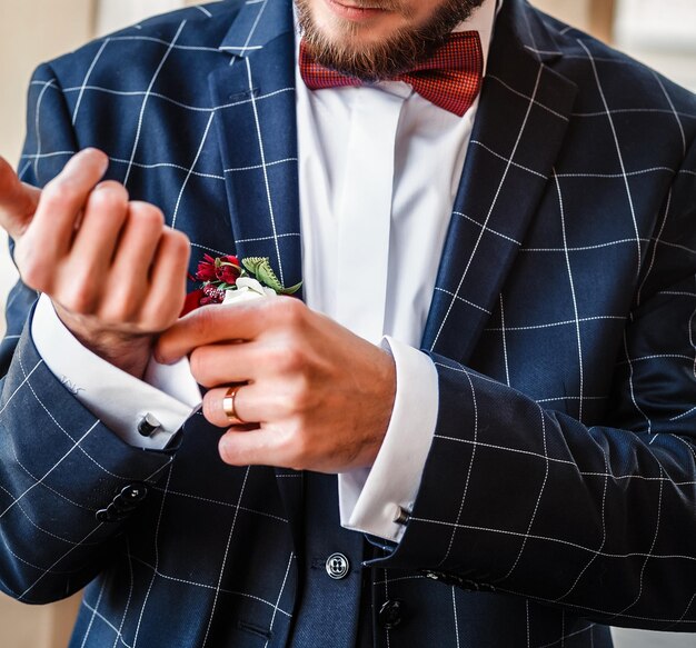 Foto el novio con una chaqueta azul se endereza.