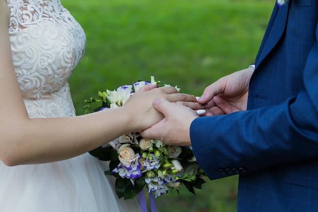 El novio coloca el anillo en la mano de la novia Primer plano de la foto