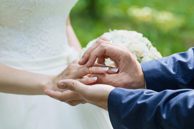 El novio coloca el anillo en la mano de la novia Primer plano de la foto