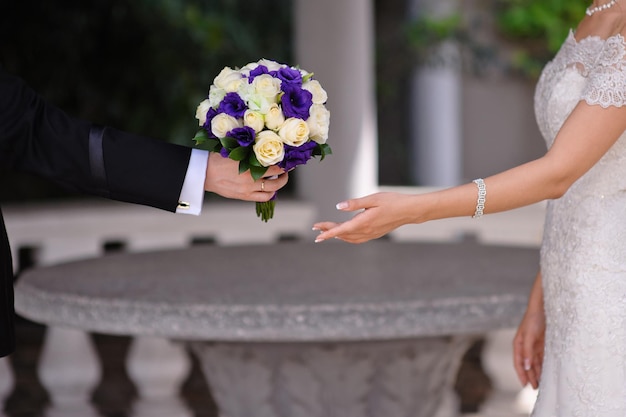 El novio le da a la novia un ramo de rosas