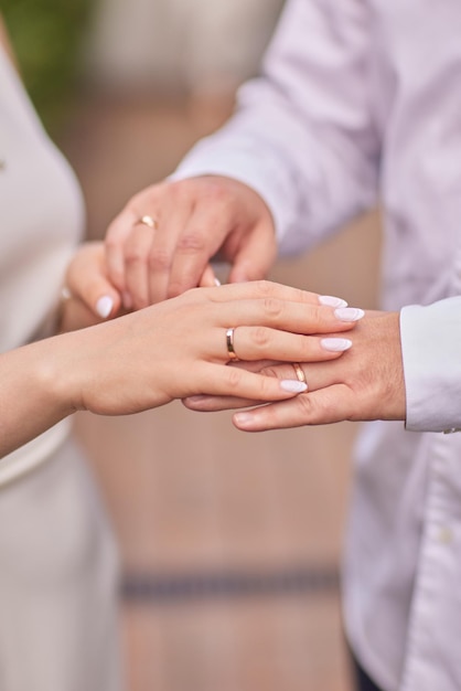 El novio está poniendo el anillo de bodas en el dedo de la novia Vista de cerca de las manos