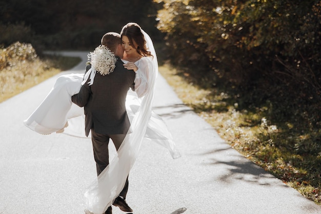 El novio gira a su novia en sus brazos contra el telón de fondo del bosque