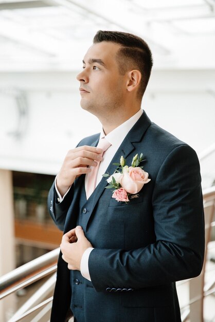 Novio guapo joven ajustando su corbata