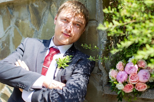 Novio guapo con un ramo al aire libre