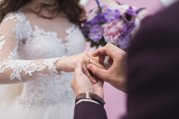 El novio lleva el anillo de la novia