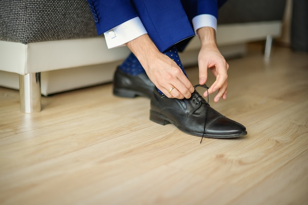 El novio lleva zapatos en traje de boda azul