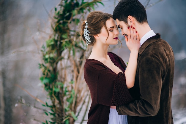 Novio en un marrón y novia en los Cárpatos de las montañas