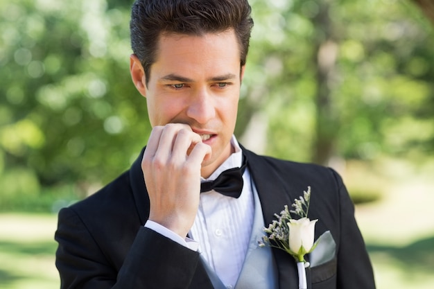 Novio morderse las uñas en el jardín