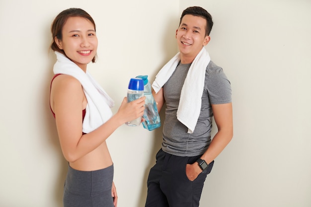 Novio y novia con botellas de agua.