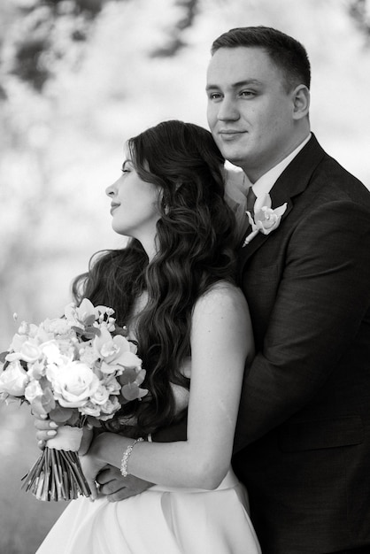 El novio y la novia caminan por el bosque.