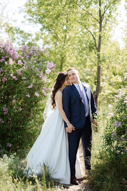 El novio y la novia caminan por el bosque.