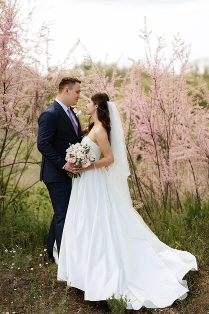 El novio y la novia caminan por el bosque.