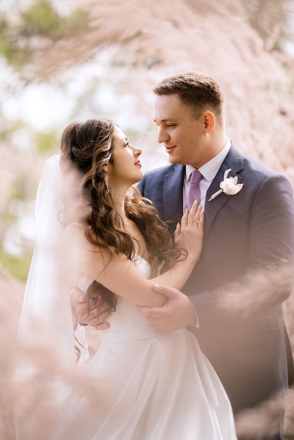 El novio y la novia caminan por el bosque.