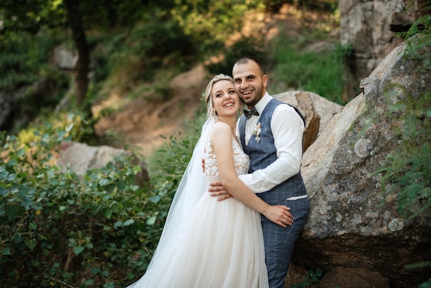 El novio y la novia caminan por el bosque.