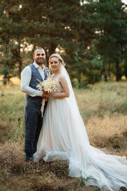 El novio y la novia caminan por el bosque.