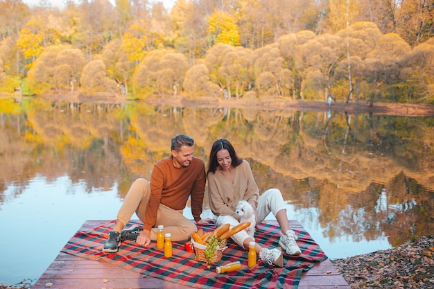 Novio con novia en día de otoño en el lago