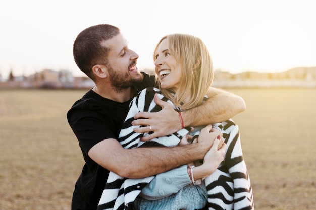 El novio y la novia enamorados de cerca pareja en el campo abrazados