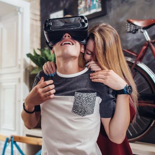 Novio y novia prueban nuevos auriculares vr 3d vision pasando tiempo juntos divirtiéndose riendo en casa