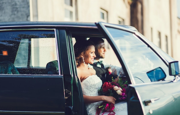 novio y novia sentada en el auto