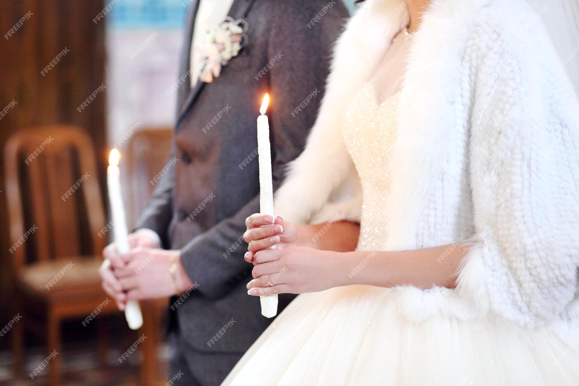 El novio de la novia sostiene en las manos una vela de boda vela encendida pareja espiritual sosteniendo velas durante la ceremonia de la boda en la iglesia cristiana de cerca | El novio de la novia sostiene en las manos una vela de boda vela encendida pareja espiritual sosteniendo velas durante la ceremonia de la boda en la iglesia cristiana de cerca |