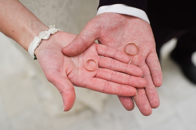 Foto el novio y la novia tienen en su mano un anillo de bodas de oro.